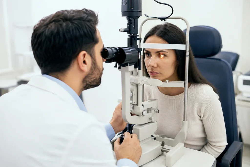 Board-certified ophthalmologist examining a patient with red itchy eyes using a slit lamp during an eye allergy evaluation