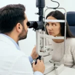 Board-certified ophthalmologist examining a patient with red itchy eyes using a slit lamp during an eye allergy evaluation